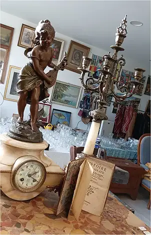 horloge statue, chandelier et ancien livre